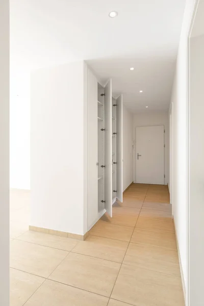 Corridor with travertine floor, white walls and built-in wardrob — Stock Photo, Image