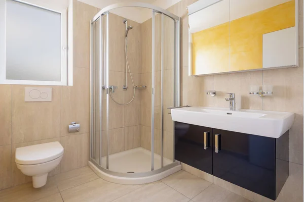 Cuarto de baño con inodoro, armario con lavabo y espejo y ducha — Foto de Stock