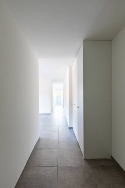 Sonunda beyaz duvarlar ve pencere olan boş bir koridor.