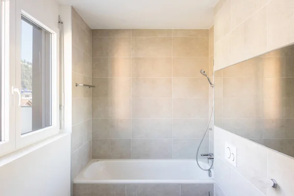 Moderno baño mínimo con bañera de azulejos grandes —  Fotos de Stock