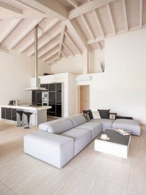 Düşük kanepeli, beyaz ve siyah mutfak esprili modern oturma odası.