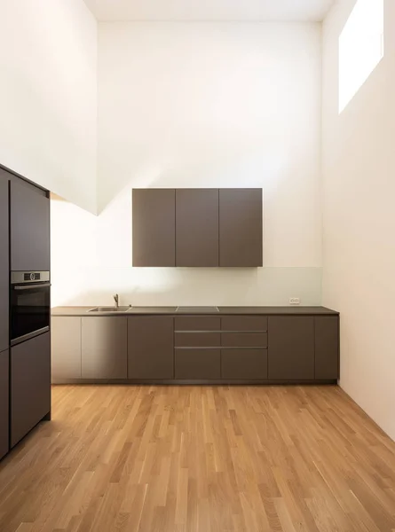 Moderní minimalistická tmavá kuchyně s parketami. — Stock fotografie