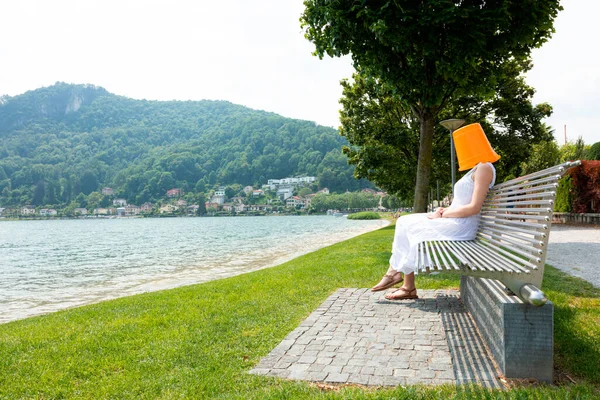 Young Woman Sitting Bench Lake Orange Bucket Her Head Secretly — Stock Photo, Image