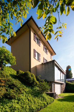 Yeşilliğin ortasında güzel bir ev modern güçlendirilmiş beton bağlantısı ve geniş bir penceresi var..