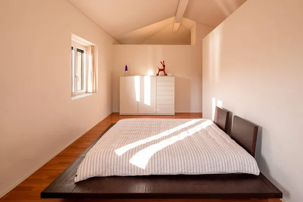 最小限のベッドルームのインテリア 1つのベッドと光のビームを入力します 床は木で作られており ベッドは低く 和風です — ストック写真