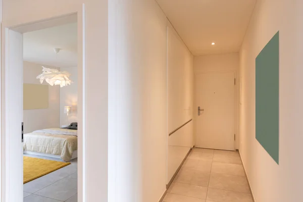 Interior of a long corridor of an apartment. At the bottom a closed door — Stock Image Interior Long Corridor Apartment Bottom Closed Door Royalty Free Stock Images