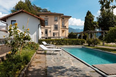 Güneşli bir yaz gününde yüzme havuzlu eski bir villa. İçeride kimse yok.