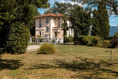 Güneşli bir yaz gününde büyük bir bahçesi olan büyük ve eski bir villa.