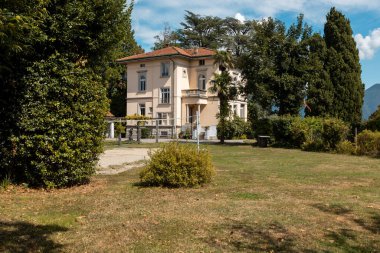 Güneşli bir yaz gününde büyük bir bahçesi olan büyük ve eski bir villa.