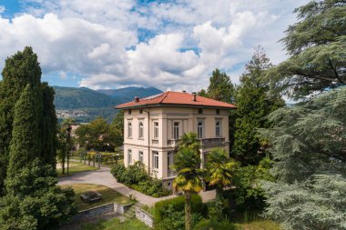 Güneşli bir yaz gününde büyük bir bahçesi olan büyük ve eski bir villa.