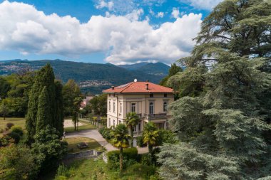 Güneşli bir yaz gününde büyük bir bahçesi olan büyük ve eski bir villa.