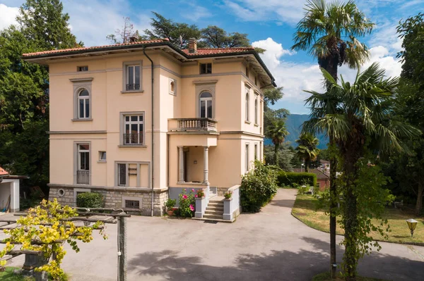 Large and old villa with large garden around it on a sunny summer day