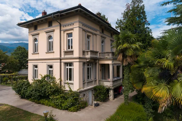 Güneşli bir yaz gününde büyük bir bahçesi olan büyük ve eski bir villa.