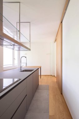 Kaputu açık modern mutfak, büyük lavabo, fırın ve ahşap atölye. Tüm mutfağın ön manzarası. İçeride kimse yok.