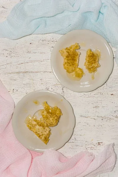 Zwei Weiße Dessertteller Mit Wabenstücken Auf Hellem Holzhintergrund — Stockfoto