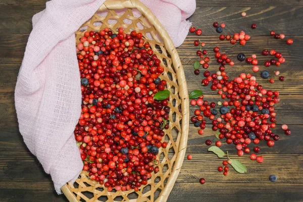 wild berries in a wicker basket on a wooden table