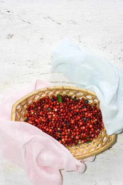 wild berries in a wicker basket on a wooden table