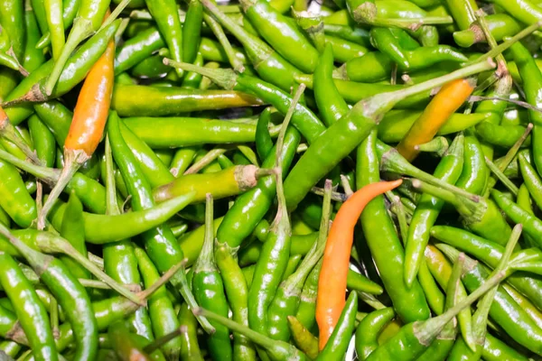 green and orange chili or peppers for sale in the Vegetable market.