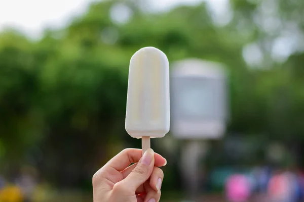 Woman holding coconut ice cream in the park, delicious so should feel fresh in summer, summer light nature background. — Stock Photo, Image