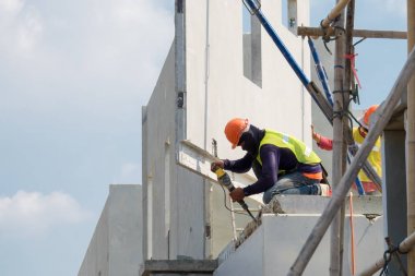 İnşaat işçisi kullanımı elektrikli matkap Sondaj beton duvar.