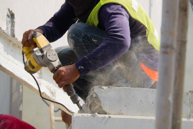 İnşaat işçisi kullanımı elektrikli matkap Sondaj beton duvar.