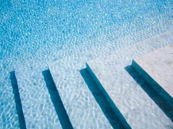 Escaliers dans la piscine, fond bleu . — Photo