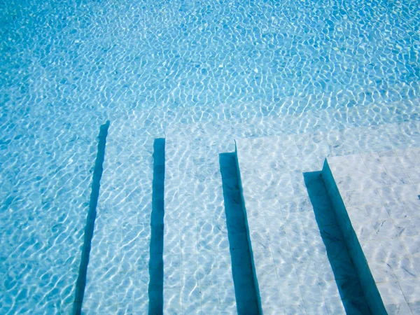 Escadas na piscina, fundo azul . — Fotografia de Stock