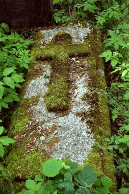 Eski yosunlu haç mezar taşı