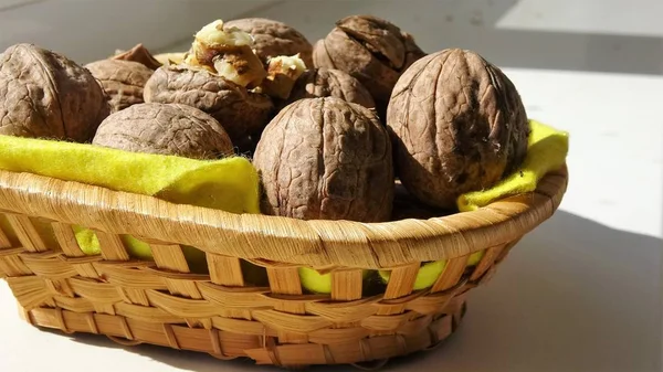 Soluk sarı tablo ve bir kase bütün ceviz, üstten görünüm üzerinde kırık ceviz ile sonbahar rustik mutfak sahne. Ceviz ahşap masa, vitaminler bir kaynak, sağlıklı bir diyet.