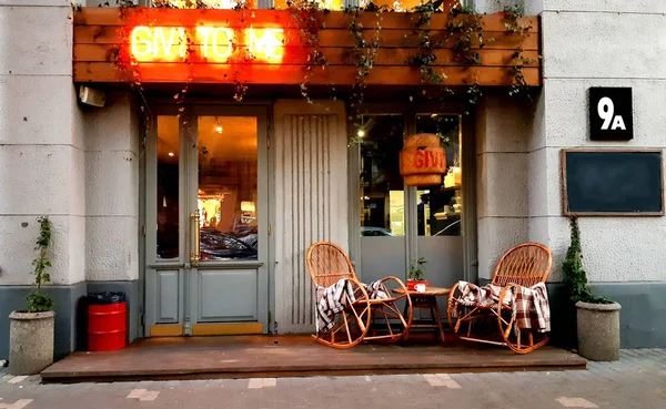 Hasır battaniye ve küçük cam masa açık havada rahat koltuk. Ekose yalanlar üzerine hasır rattan mobilya.