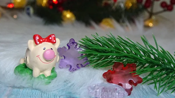 Porco de brinquedo e decoração de inverno, parabéns pelas férias. Símbolo do ano do porco no fundo das luzes de Natal — Fotografia de Stock