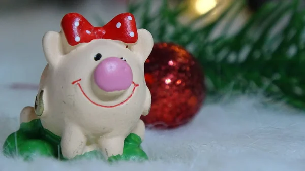 Toy pig and winter decor, congratulations on the holiday. Symbol of the year of the pig on the background of Christmas lights — Stock Photo, Image