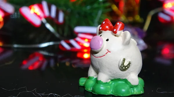 Domuz oyuncak ve kış dekor, tebrikler tatilde. Noel ışıkları arka plan üzerinde domuz yılı sembolü