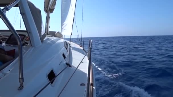 Una vista desde la cubierta de yates a la proa y las velas, vista de primer plano.S ide con mar azul y olas . — Vídeo de stock