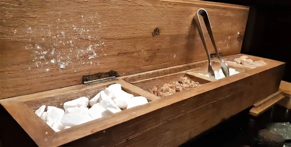 Bir grup rock şeker. Ahşap kutu kahverengi şeker küpleri. Çeşitli çay ve şeker ahşap masa üzerinde çeşitli tür