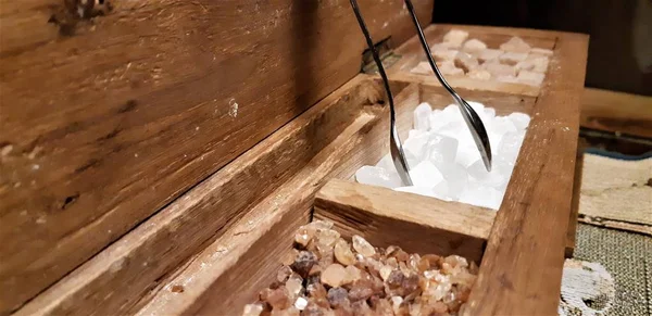 Bir grup rock şeker. Ahşap kutu kahverengi şeker küpleri. Çeşitli çay ve şeker ahşap masa üzerinde çeşitli tür