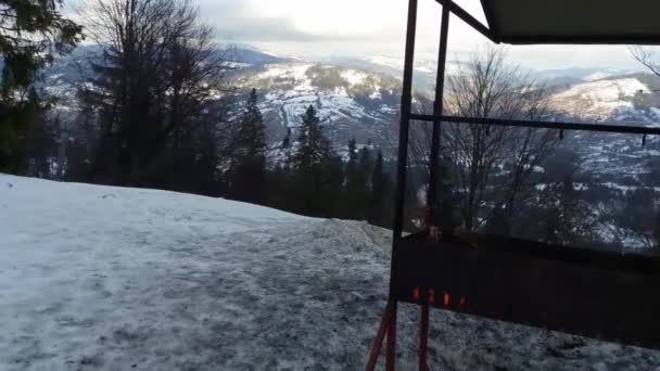 Brand van houten logboeken in brazier in sneeuw op de top van een besneeuwde berg. — Stockvideo