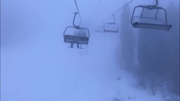 La silla de esquí alpino ascensor en la niebla. nublado día de nieve en las montañas . — Vídeos de Stock