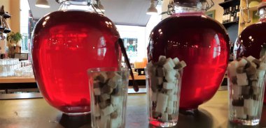 Cam kavanozlarda konserve meyve içer. Kavanoz çilek kompostosu. Komposto bir ahşap raf, birkaç renkli kutular. Seçici odak. Sığ derinlik-in tarla.