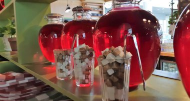 Cam kavanozlarda konserve meyve içer. Kavanoz çilek kompostosu. Komposto bir ahşap raf, birkaç renkli kutular. Seçici odak. Sığ derinlik-in tarla.