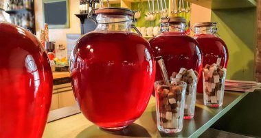 Cam kavanozlarda konserve meyve içer. Kavanoz çilek kompostosu. Komposto bir ahşap raf, birkaç renkli kutular. Seçici odak. Sığ derinlik-in tarla.