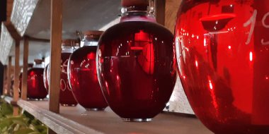 Cam kavanozlarda konserve meyve içer. Kavanoz çilek kompostosu. Komposto bir ahşap raf, birkaç renkli kutular. Seçici odak. Sığ derinlik-in tarla.