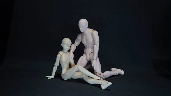 Dois modelos de arte manequim representando um abraço romântico sobre fundo preto. conceito de sentimentos — Fotografia de Stock