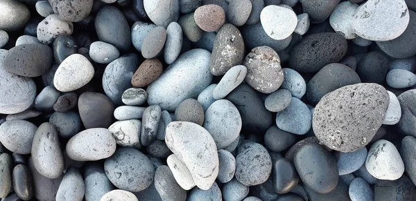 海の小石のクローズ アップ。さまざまな形状とサイズのビーチ小石の背景 — ストック写真