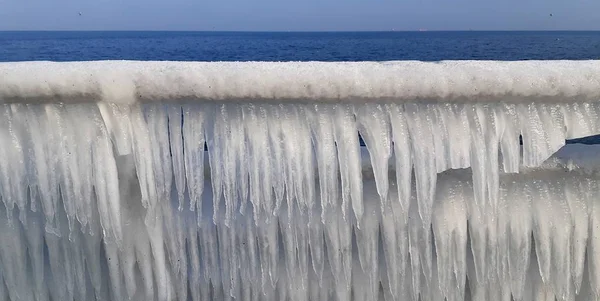 Belos pingentes de gelo contra o fundo do mar, e água. tempo frio e gelado transformou a água em gelo . — Fotografia de Stock