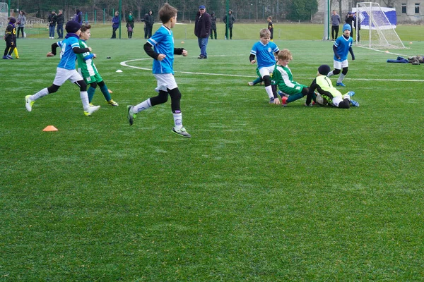 Gyermek labdarúgó-válogatott a pályán. Gyermek labdarúgó földi képzés. Fiatal focisták futás után a labda. — Stock Fotó