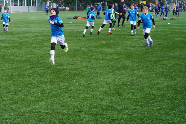 Детская футбольная команда на поле. Детский футбольный стадион. Молодые футболисты бегут после мяча . — стоковое фото