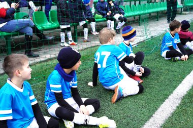 Yedek oyuncular olarak genç erkek. Birlikte alanında oturup ve futbol maçı izlerken gençlik futbol futbol takımı