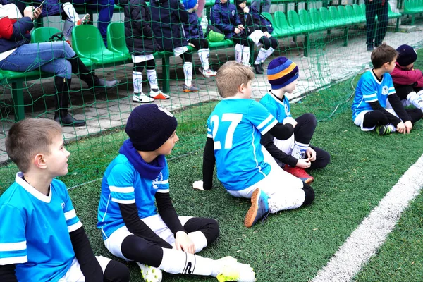 Giovani ragazzi come giocatori di riserva. Gioventù squadra di calcio seduto insieme sul campo e guardare la partita di calcio — Foto Stock