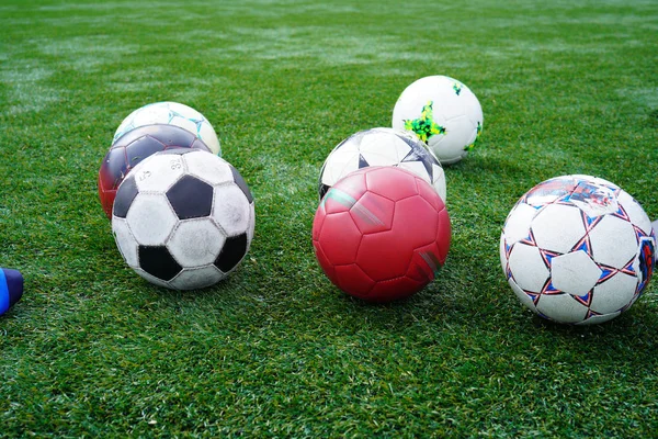 Soccer balls on a soccer field during practice time. Ball on green grass of stadium. Soccer Football on white line of Soccer field background. — Stock Photo, Image
